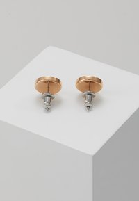 Runde stud øreringe med en poleret roseguldfinish, metalliske stifter og en glat overflade. Simpelt design uden yderligere mønstre eller accenter.