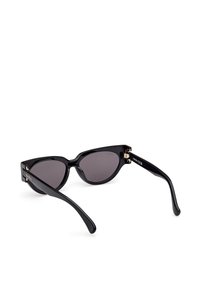 Ochelari de soare de tip cat-eye negri cu lentile gri, având un finisaj lucios, accente din aur pe ramă și brațe negre elegante.