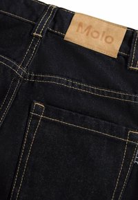 Black denim jeans featuring a classic design, visible stitching in a contrasting yellow, and a light brown leather patch labeled "Molo."