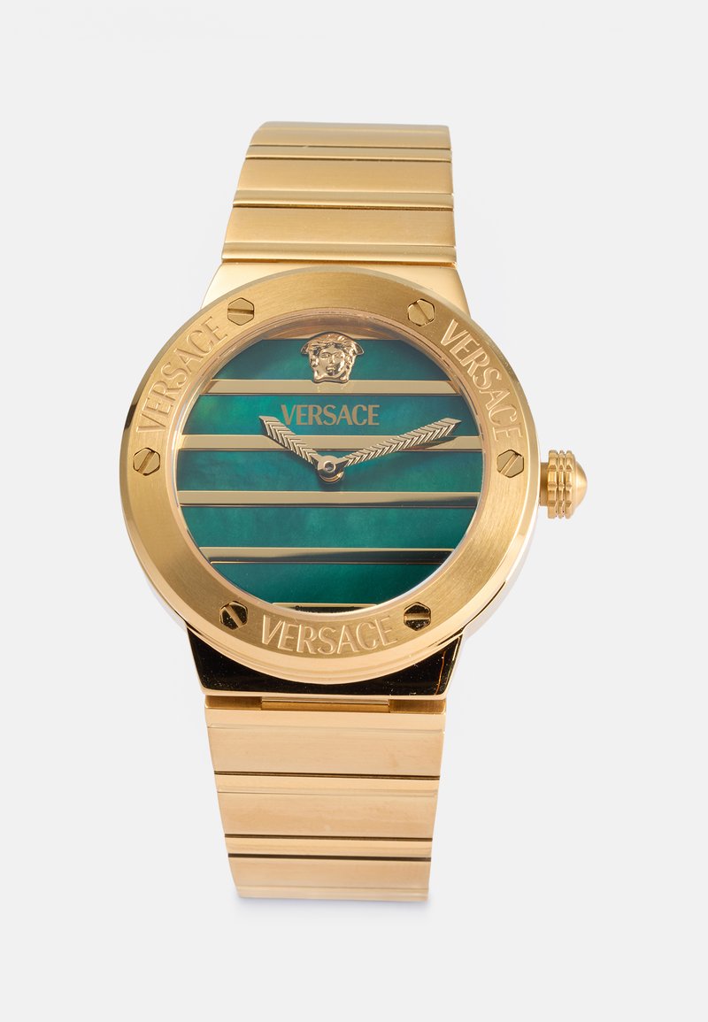 Χρυσής απόχρωσης ρολόι Versace με στρογγυλό καντράν και πράσινο ριγέ ταμπλό, με λογότυπα και υφασμένη μεταλλική αλυσίδα.