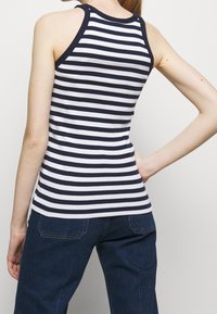 Randig linne i marinblått och vitt med horisontella ränder, ribbad textur och rund halsringning med matchande ärmhålskant.