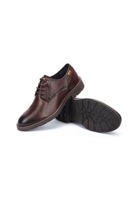 Chaussures en cuir marron avec bout rond, design à lacets, couture contrastante et semelle en caoutchouc texturée. Présente un logo subtil sur le côté.