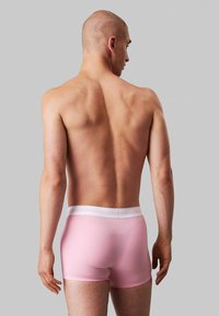 Boxer da uomo in cotone rosa con vita elastica bianca. Tessuto liscio, design aderente e taglio a vita media. Vista posteriore mostrata.