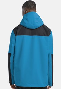 Veste imperméable bleue et noire avec capuche, présentant un design en panneaux et une texture lisse, vue de dos.