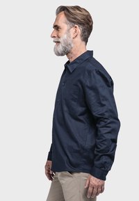 Marineblaues Hemd mit Knöpfen, aus einem strukturierten Stoff, mit einer Brusttasche und einem Kragen, langen Ärmeln und einer lockeren Passform.