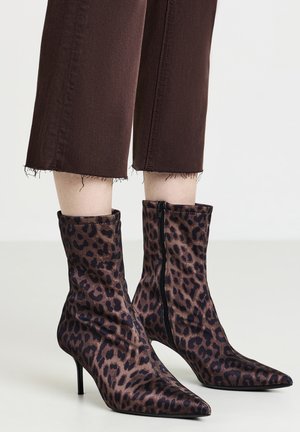 Stivali ankle con stampa leopardata, punta affusolata, design elegante, parte superiore aderente e zip laterale. Tessuto liscio con tacco alto.