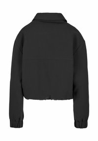 Veste courte noire avec manches longues, poignets élastiques et col, vue de dos sur fond blanc.