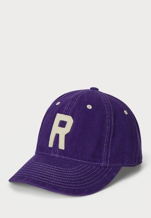 Casquette de baseball en coton violet avec un bord renforcé, ornée d'un grand "R" blanc brodé à l'avant et d'accents de couture blanche.