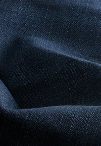 Tăbăcitură din denim indigo întunecat cu o textură netedă, având o țesătură strânsă și un luciu subtil. Suprafața prezintă o culoare și un model uniform.