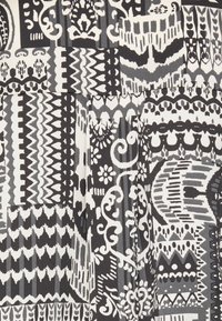 Black and white patterned fabric featuring a mix of zigzag, floral, and swirled designs, with varying shapes and textures.