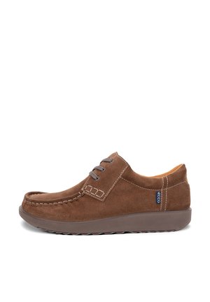 Brown suede moccasin shoes worn with blue jeans on a flat, light gray surface.