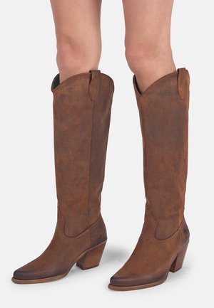 Bruine leren kniehoge laarzen met een spitse neus en een gestructureerde afwerking, voorzien van een gestapelde hak en zijhandvatten voor eenvoudig aan- en uittrekken.
