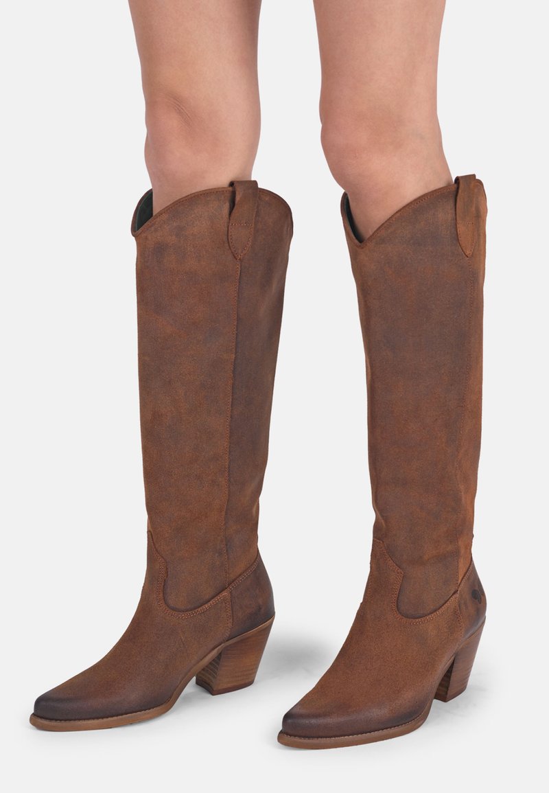 Bottes en cuir marron, hauteur genou, avec un bout pointu et une finition texturée, dotées d'un talon empilé et de languettes sur les côtés pour un enfilage facile.