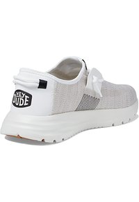 Scarpa slip-on leggera in rete grigia con suola in gomma bianca, caratterizzata da un'etichetta con logo e minimi contrasti neri sul tallone e sul lato.