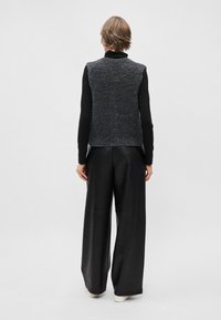 Hallikas, reljeefne sansärkm ja must pikk varrukas särk, koos laiade mustade nahkpükstega. Riietuse täiendavad kerge taldadega jalanõud.