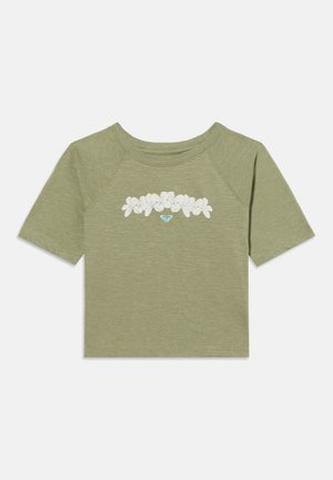 Hellolivgrünes kurzärmeliges Crop-Top mit rundem Ausschnitt und weißem Blumenmuster über der Brust, in der Mitte mit kleinem blauem Herzlogo.