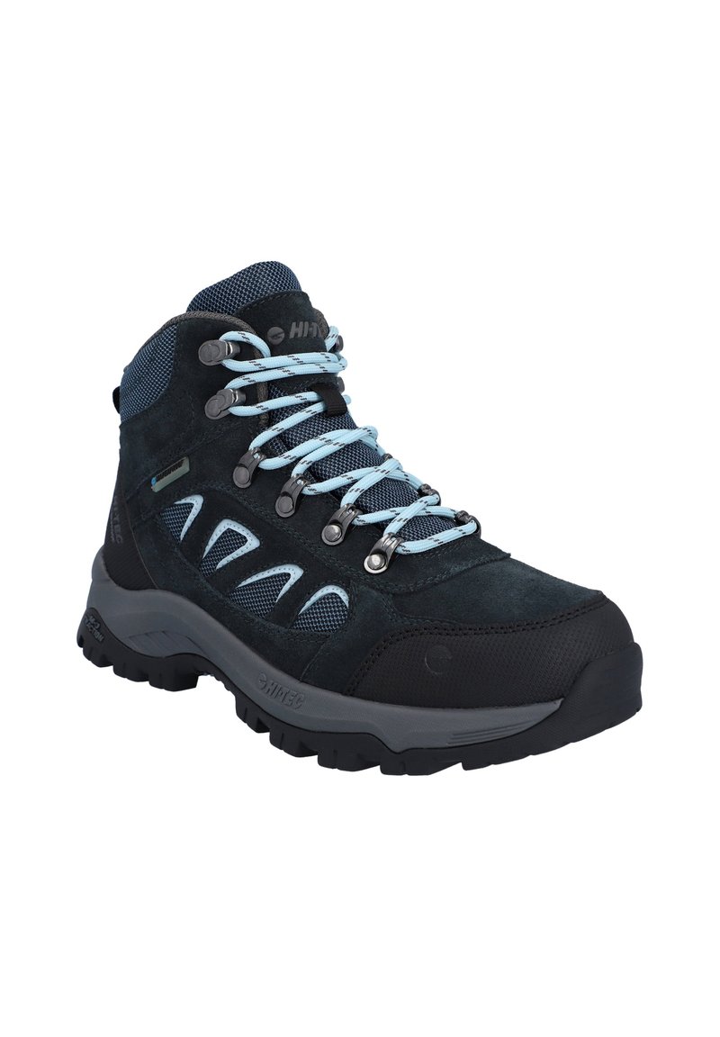 Mid-Cut-Wanderschuh aus dunkelblauem Wildleder mit Netzakzenten. Hellblaue Schnürsenkel und Metallösen, ausgestattet mit einer strukturierten schwarzen Gummisohle.