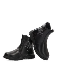 Botas negras de tobillo hechas de cuero suave, con un diseño de estrella y acentos de strass en los lados, y una suela de goma texturizada.