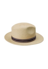 Beige halmhat med bred brem, utstyrt med et mørkt stripete bånd rundt bunnen. Den vevde teksturen gir et luftig utseende.