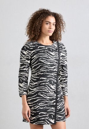 Black and white zebra-striped dress with long sleeves, round neckline, and a button closure along the side. Textured fabric with a fitted design.