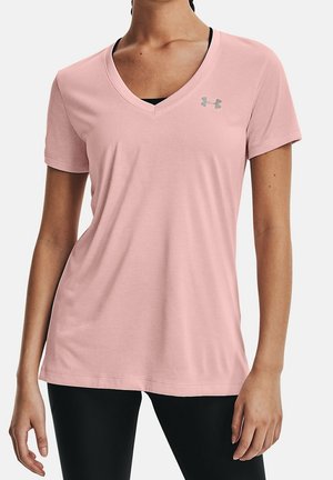 Vrouw draagt een lichtroze V-hals T-shirt met korte mouwen met een klein Under Armour-logo op de borst en zwarte legging.