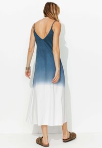 Robe longue sans manches avec un dégradé de bleu à blanc, fabriquée en tissu léger, avec un dos en V et des bretelles réglables.