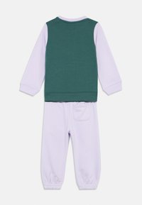 Δίδυμο ρουχισμού για παιδιά, με πράσινο αμάνικο γιλέκο πάνω από μακρυμάνικο λουλουδάτο μπλουζάκι σε λεβάντα και στα ταιριαστά παντελόνια σε λεβάντα με ελαστικούς μανσέτες και πίσω τσέπη.