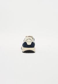 Tenis navy cu un guler alb și bej, material din suede texturat, talpă groasă, și brandul "New Haven" pe călcâi.