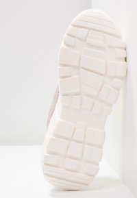 Semelle de sneaker en caoutchouc blanc avec motif d'adhérence texturé. Le côté présente des accents irisés multicolores. Forme moderne et épaisse.