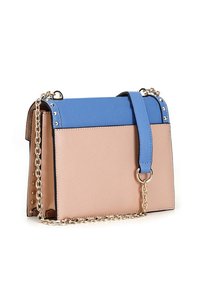 Borsa a blocchi di colore con parte superiore blu e parte inferiore beige, dotata di una tracolla a catena, dettagli borchiati e una forma rettangolare strutturata.