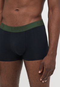 Black boxer briefs with a green Levi's logo waistband. The fabric appears soft with a smooth texture, featuring a fitted design.
