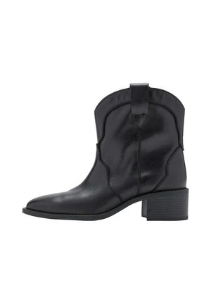 Botín negro de cuero con tacón bajo cuadrado y lengüeta, con puntera puntiaguda y costuras decorativas.
