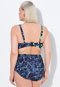 Simset med bikini i lila och teal leopardmönster, justerbara remmar och bakspänne. Högmidjad botten med en mjuk textur.