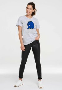 Gray short-sleeve t-shirt featuring a blue cartoon elephant graphic. Paired with black leggings and white sneakers. Smooth fabric texture.