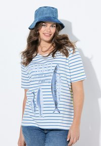 Blau-weiß gestreiftes T-Shirt aus Baumwolle, mit bedruckten Fischmotiven. Kombiniert mit einem blauen Fischerhut. Legere Passform und kurze Ärmel.