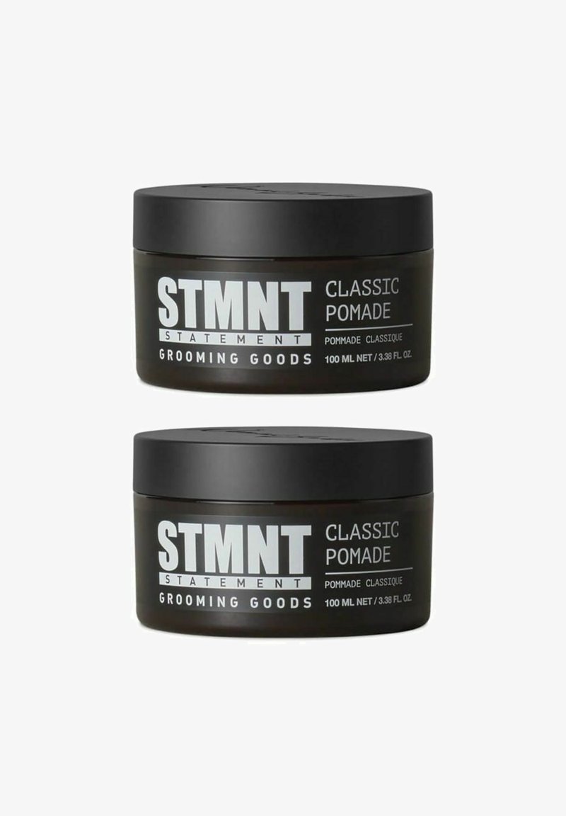 Zwei schwarze runde Töpfe mit STMTNT Classic Pomade, jeweils mit weißem Text etikettiert und mit einem Volumen von 100 ml, die eine glatte matte Oberfläche aufweisen.