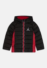 Czarna i czerwona puchowa kurtka z kapturem, z zamkiem błyskawicznym z przodu, bocznymi czerwonymi panelami oraz białym logo Jumpman na lewej piersi.