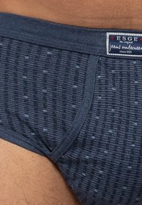 Marineblaue Unterwäsche aus strukturiertem Stoff mit einem Muster aus kleinen Linien. Verfügt über einen markierten Bund mit sichtbarem "ESGE"-Tag.