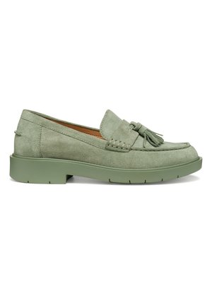 Mocassin en daim vert clair avec détail à pompons, accents cousus et semelle épaisse en caoutchouc, présenté de profil sur un fond blanc.