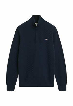 Pull à col zip navy avec un motif texturé, des côtes aux poignets et à l'ourlet, arborant un petit logo brodé sur la poitrine.