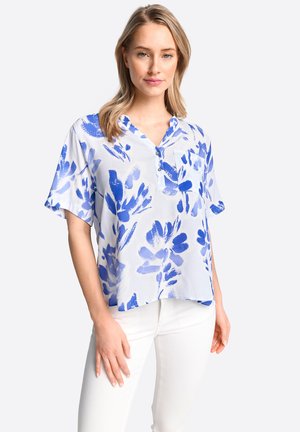 Bluse mit kurzem Arm im blauen Blumenmuster, V-Ausschnitt und Knopfleiste. Leichter Stoff, lockere Passform und eine Fronttasche.