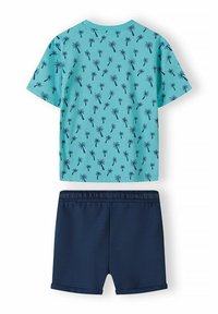 Camiseta de manga corta turquesa con patrón de palmeras negras, combinada con pantalones cortos de color marino con cintura elástica. Material de algodón suave.