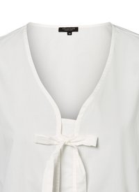 Weißes Bluse mit tiefem V-Ausschnitt und einer mittleren Partie, die mit einer Schleife gebunden ist. Hergestellt aus glattem Stoff mit leichter Textur. Größe 36.