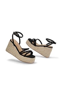 Sandalias de cuña negras con tiras, con una plataforma de yute tejido y textura trenzada, que cuentan con correas en el tobillo y un diseño de punta redondeada.