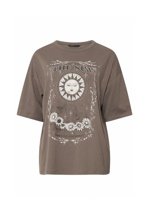 Oversized bruine T-shirt met een zonnengezicht, vlinders, witte bloemen, sterren en de tekst "THE SUN" en "Your existence is magic."