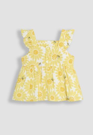 Žuti cvjetni top s naboranim rukavima, s uzorcima suncokreta i malim detaljima pčela. Zatvaranje na gumbe sprijeda. Pamuk.