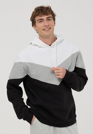 Felpa con cappuccio caratterizzata da un design a blocchi di colore in bianco, grigio e nero. Realizzata in tessuto morbido, con tasca kangaroo e cappuccio regolabile con coulisse.