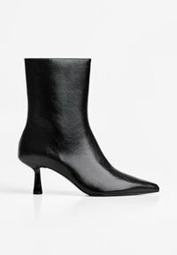 Zwarte enkelboot van glad leer, met een spitse neus, slanke hak en een minimalistisch ontwerp zonder zichtbare patronen of versieringen.