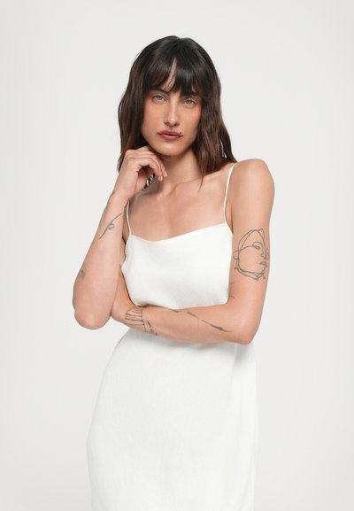 Vestido blanco sin mangas con escote cuadrado, hecho de una tela texturizada. Presenta tirantes finos y una silueta fluida.