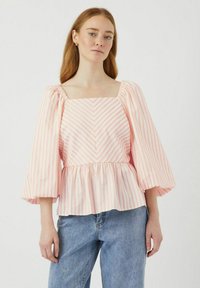 Blusa a righe rosa e bianche con scollatura quadrata, maniche a sbuffo e vita arricciata. Realizzata in un tessuto leggero con una texture liscia.